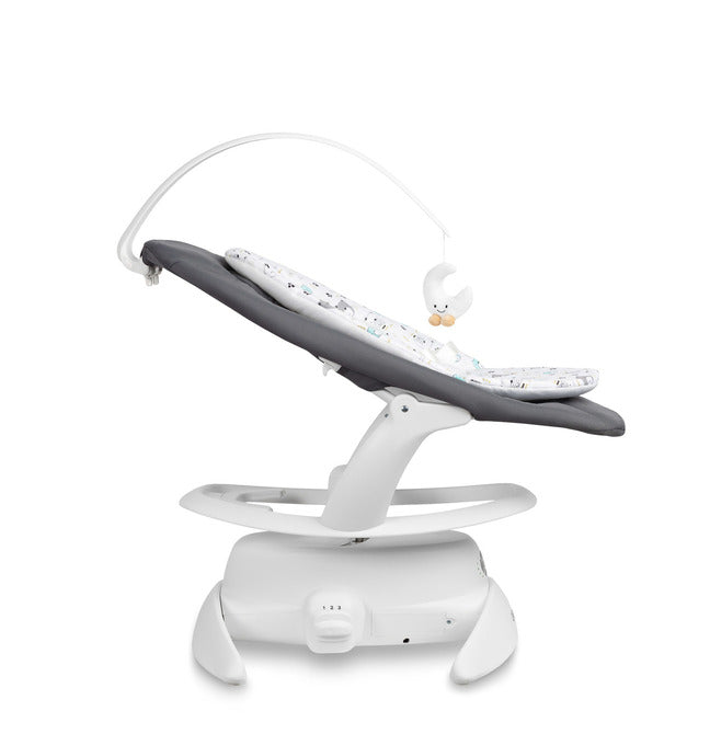 An electric baby rocker Noco featuring a bar and melodies, designed for babies and infants. The rocker have a graphite seat with a patterned fabric, white frame, and a variety of controls and accessories, such as a safety bar and sensory toy.