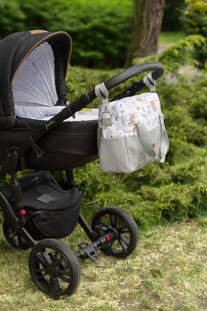 The eco-leather bag is perfect not only for a stroller. It has many advantages, such as: eco-leather bottom, internal pockets, functional compartments and a lining resistant to dirt. On the other hand, colored cotton with a print makes the bag suitable for modern strollers. In addition, the bag is equipped with metal fittings, universal hooks to hang on the frame and a practical shoulder strap.