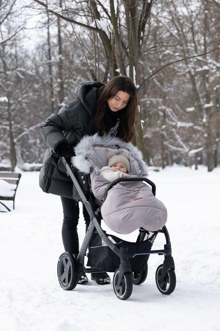 Orso romper bag has a waterproof, easy to keep clean over layer with aesthetic quilting. On the inside there is a layer of soft polar fleece. The layer of fluffy, anti-allergic nonwoven fabric provides effective protection and comfort. Artificial fur by the hood that can be unfastened makes it look exceptional. The romper bag fits pushchairs of any style. It can be used in prams, strollers, and for sledges. It has holes for belts and a zip at the entire length.